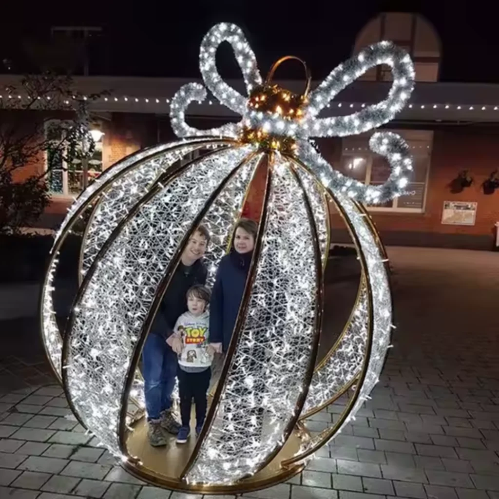 A spherical LED ornament with a white glowing bow, designed for walk-through experiences.